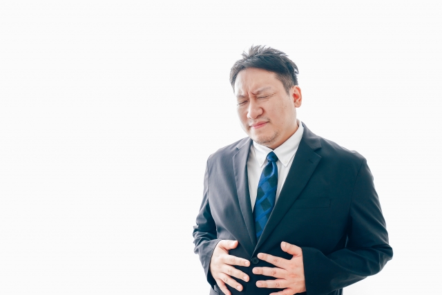 胃痛に苦しむスーツを着た中年男性